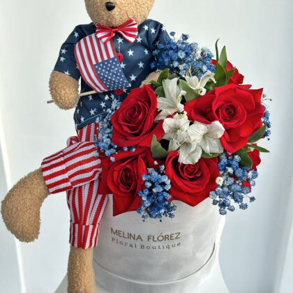 Our Liberty bear accompanied by red roses, white astromelias and blue Baby Breath.