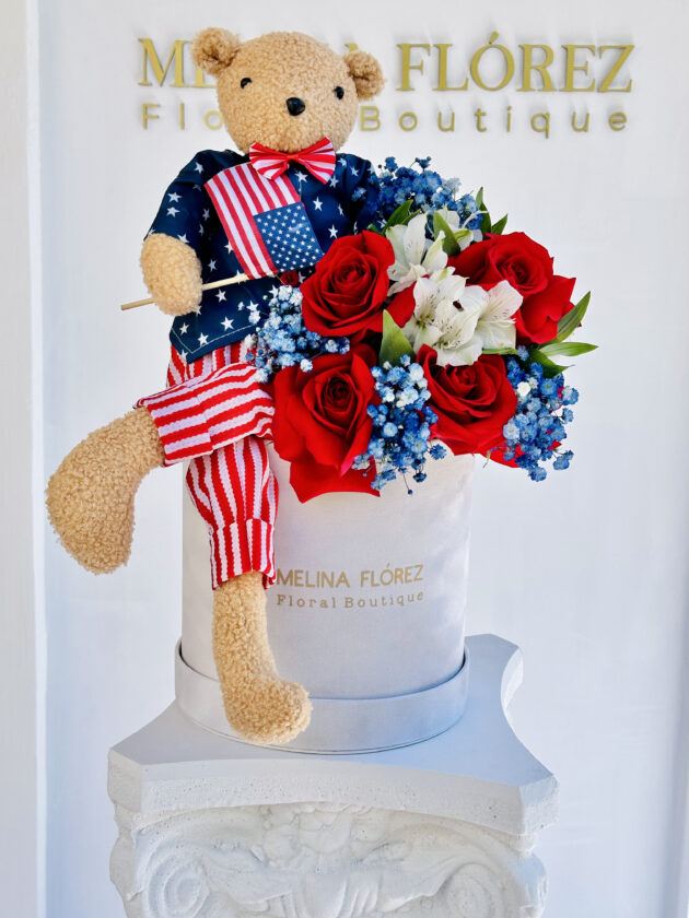 Our Liberty bear accompanied by red roses, white astromelias and blue Baby Breath.