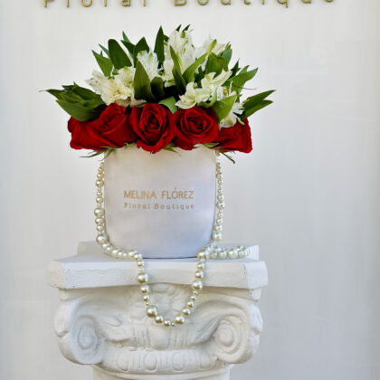 Small white velvet box with a beautiful pearl arrangement in red roses and white astromelias. It is a classic must-have
